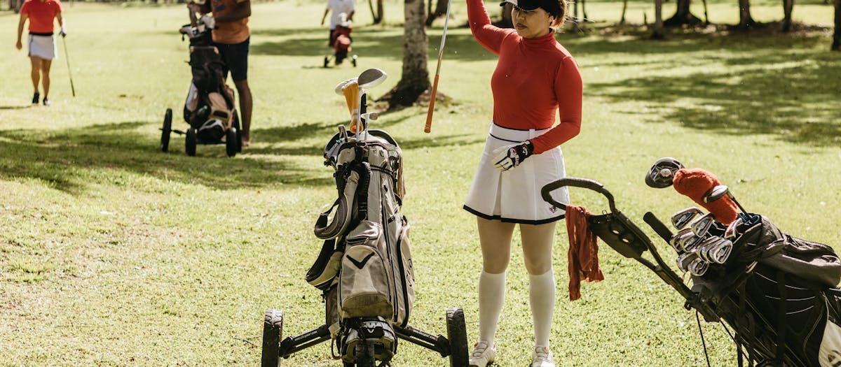 Golfers playing and relaxing on a sunny day at a lush green course.